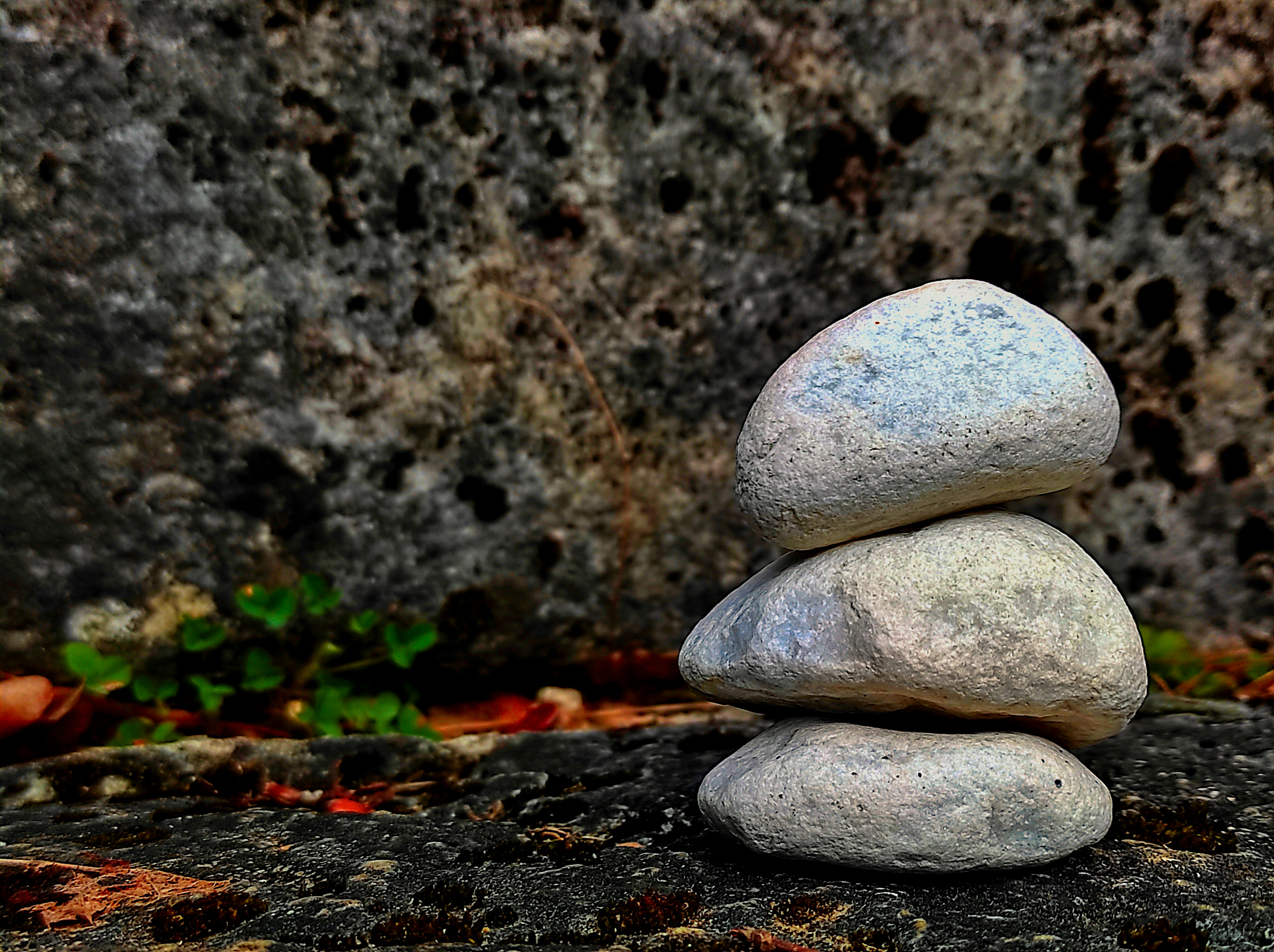 A small, carefully balanced stack of rocks on top of a larger rock